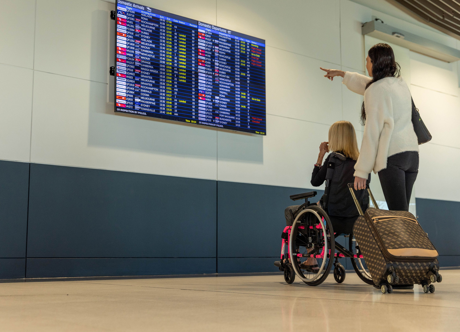Accessible traveller looking at flight information at the Domestic Terminal