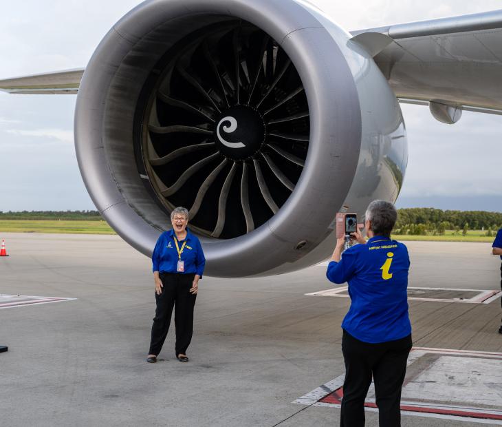 ambassadors taking photos in front of a plane