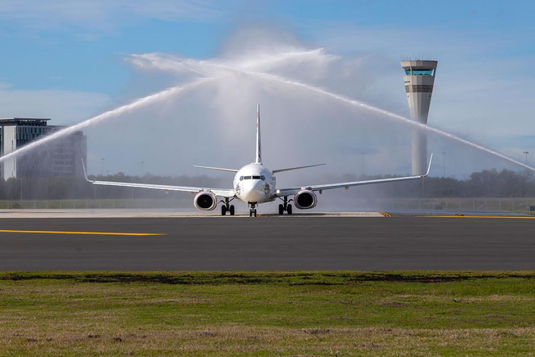 First plane on the new Brisbane Runway with fire trucks shooting water cannons to welcome it