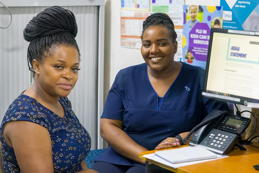 A women and a nurse sitting at a desk