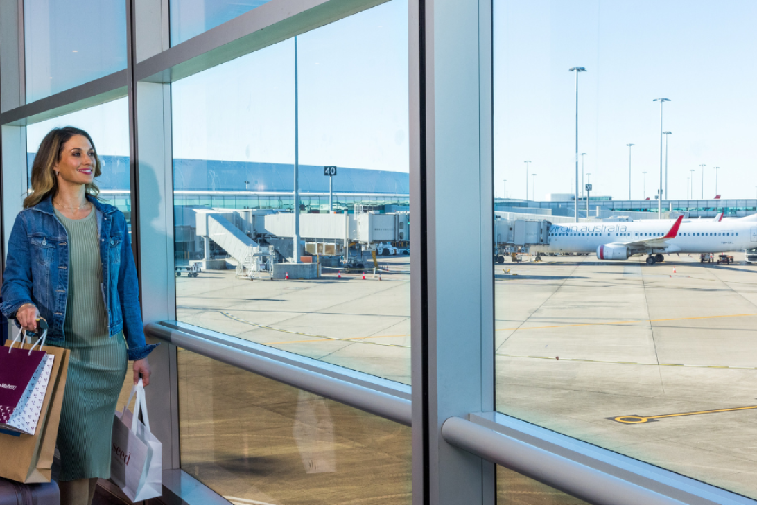Person with shopping bags looking at runway